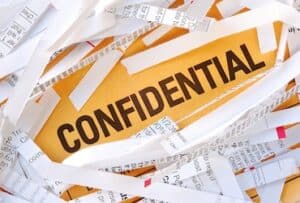 The word Confidential surrounded by some shredded papers