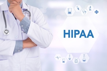 The word HIPAA and medical icons float in the foreground next to an image of a medical professional in a white jacket and wearing a stethoscope.