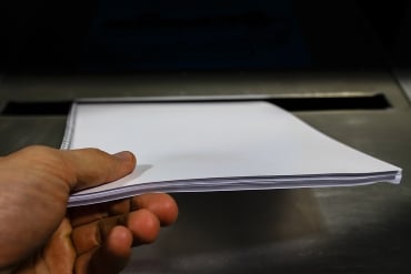 Dropping of paper in a metal bin container for safe disposal of business documents