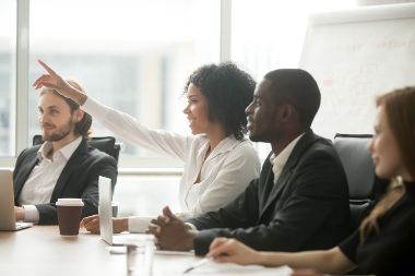 Woman raising hand to ask question at team training