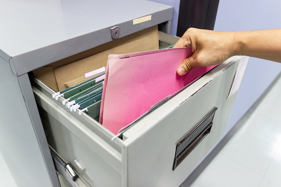 Close up Hand of a person Search files document in a file cabinet in work office.